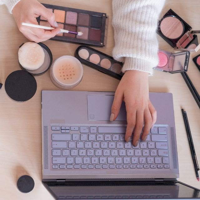 hand on makeup and laptop